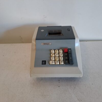 Calculadora sumadora vintage Totalia. Es un modelo de sobremesa con cuerpo de plástico bicolor (crema y gris oscuro). Lagomarsino S.p.A. fabricó estas máquinas, siendo uno de los últimos modelos mecánicos en el mercado hasta 1975. Alquiler para eventos, publicidad, series, películas