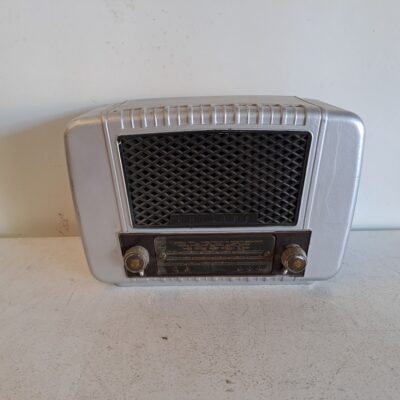 Radio de válvulas Philips de baquelita. El diseño es de estilo vintage con una carcasa de baquelita plateada y una rejilla frontal de tela negra. Alquiler para eventos, publicidad, series, películas.