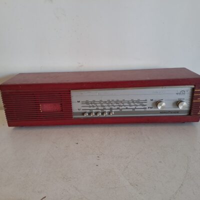 Radio vintage roja Nordmende Spectra Phonic de los años 60, fabricado en Alemania. Es una radio de sobremesa con sintonizador AM/FM y un distintivo acabado en color rojo o madera según la versión. Alquiler para eventos, publicidad, series, películas.