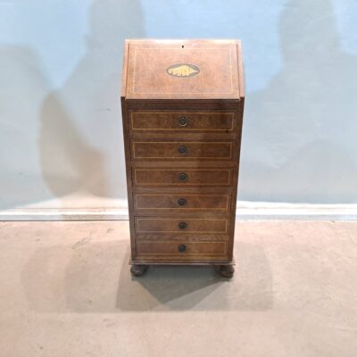 Bureau es un tipo de escritorio clásico conocido también como secreter. Combina las funciones de un escritorio y una cómoda o cajonera, ideal para espacios donde se necesita tanto una superficie de trabajo como almacenamiento. Alquiler para eventos, publicidad, series, películas.