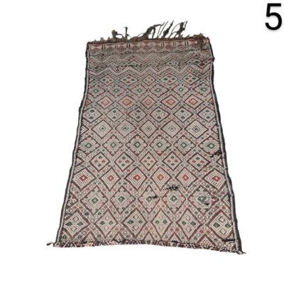Alfombra tipo kilim bereber vintage de Marruecos, caracterizada por sus intrincados patrones geométricos de rombos en tonos rojos, blancos y verdes sobre un fondo oscuro alquiler para eventos, publicdad, peliculas y series