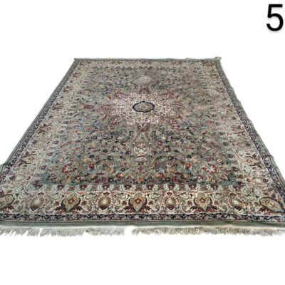Alfombra persa de estilo tradicional con un intrincado diseño floral y un medallón central en tonos azules, verdes y burdeos alquiler para eventos, publicidad, peliculas y series