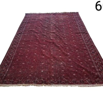 Alfombra afgana de lana anudada a mano con un característico color rojo burdeos y motivos geométricos tradicionales alquiler para eventos, publicidad, peliculas y series