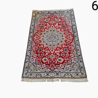 Alfombra persa de lana anudada a mano, posiblemente de la región de Kashan o Isfahan, que presenta un diseño clásico de medallón central en tonos rojos y azules alquiler para eventos, publicidad, peliculas y series