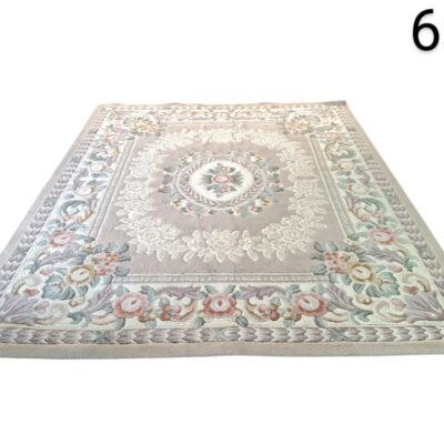 Alfombra beige con diseño floral es una pieza de estilo clásico, posiblemente inspirada en los diseños franceses de Aubusson alquiler para eventos, publicidad, peliculas y series