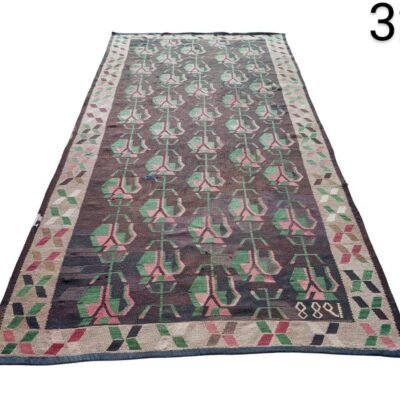 Vintage Kilim Ikat wool rug with geometric pattern in brown and pink tones for rent for events, advertising, films and series.