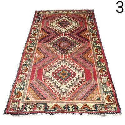 Turkish hand-woven Kilim rug, characterised by its tribal geometric patterns in red and brown tones, for rent for events, advertising, films and series.