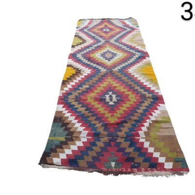 Kilim type carpet of Turkish origin, characterised by its vibrant geometric patterns and its flat weave technique, for rent for events, advertising, films and series.