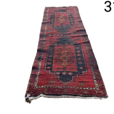 Hand knotted wool hallway rug with a traditional Afghan tribal geometric design in red and black tones for rent for events, advertising, films and series.