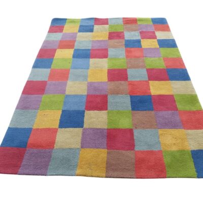 Alfombra de lana hecha a mano diseñada por Nanimarquina con un patrón de cuadros multicolor alquiler para eventos, publicidad, peliculas y series