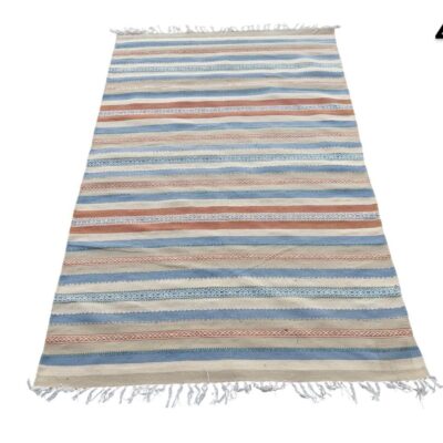 Multicoloured flat weave kilim style carpet with horizontal stripes in blue, beige and terracotta tones for rent for events, advertising, films and series.