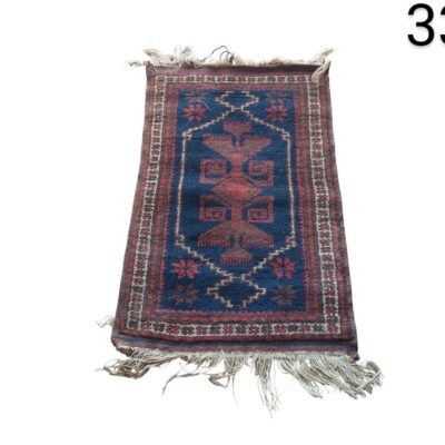 Small Persian or Turkish style carpet with a traditional geometric design in blue and red tones for rent for events, advertising, films and series.