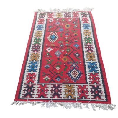Alfombra tipo kilim vintage de tejido plano, caracterizada por sus colores vibrantes y motivos geométricos tribales alquiler para eventos, publicidad, peliculas y series