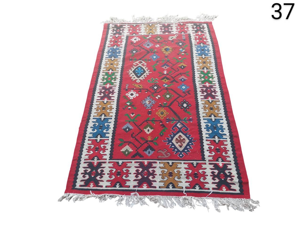 Vintage kilim type flat weave carpet, characterised by its vibrant colours and tribal geometric motifs, for rent for events, advertising, films and series.