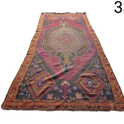 Vintage turkish wool rug with a geometric pattern in pink and plum tones for rent for events, advertising, films and series.