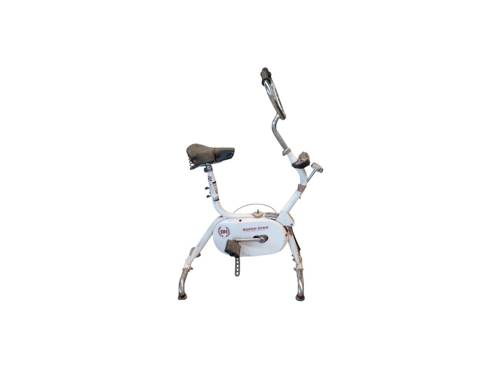Bicicleta estática vintage de la marca BH, modelo Home-Bike, que destaca por su estructura de color blanco y manillar cromado alquiler para eventos, publicidad, peliculas y series